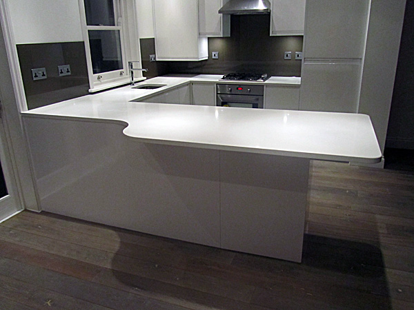 Pure White [CAESARSTONE] quartz kitchen worktops with brown glass splashbacks Chiswick